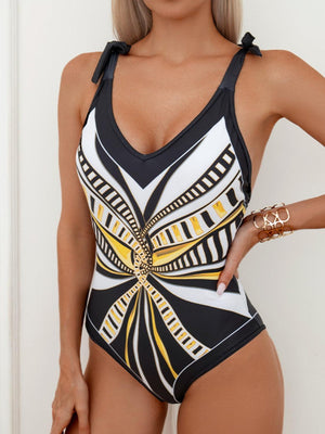 a woman in a black and white one piece swimsuit