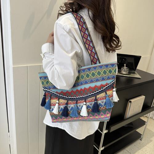 a woman holding a multicolored bag with tassels