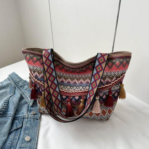 a handbag and a pair of jeans on a bed