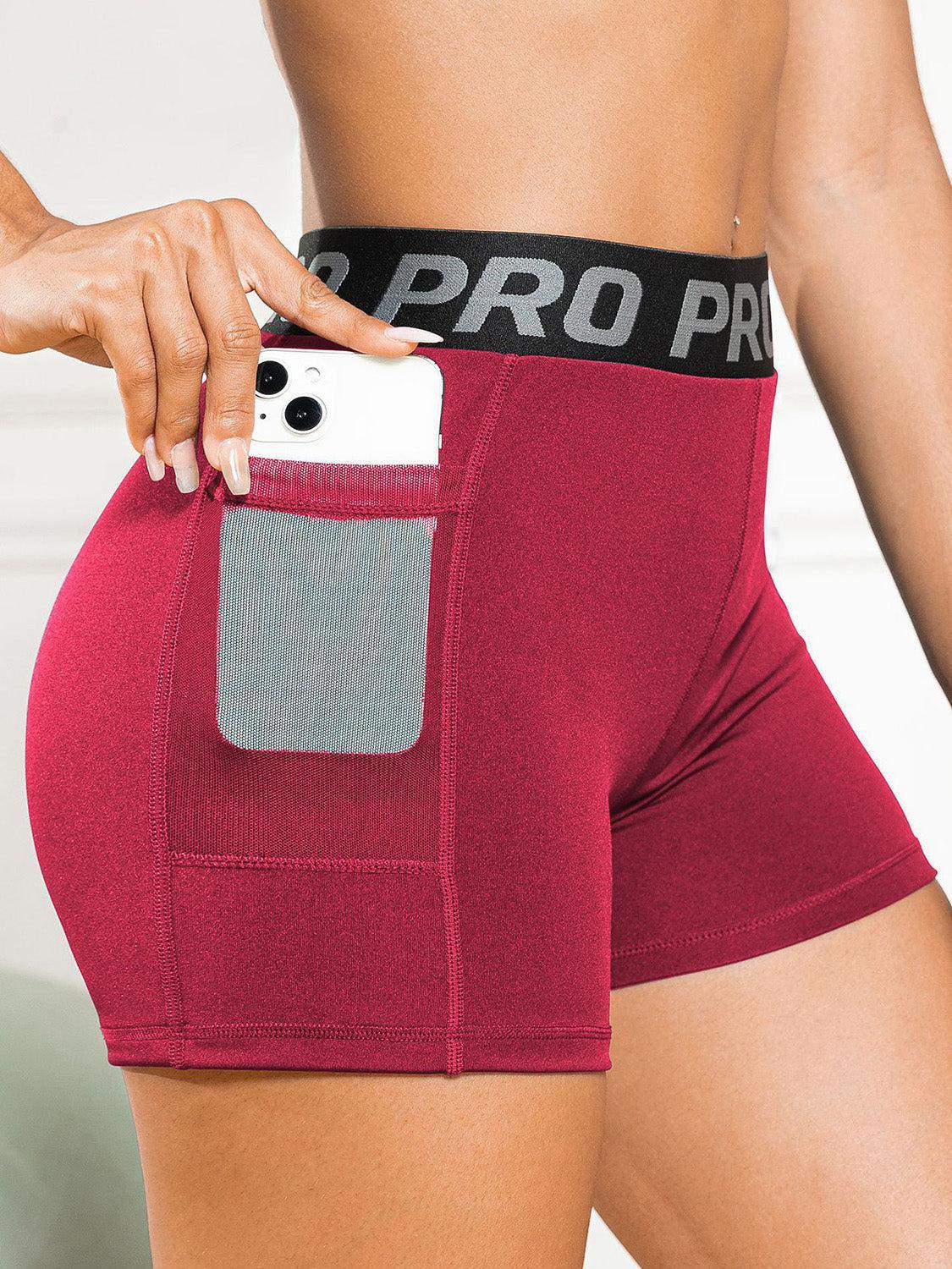 a woman in red shorts holding a cell phone