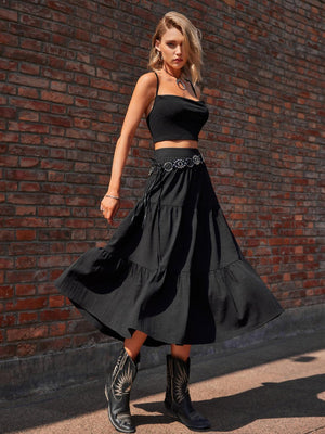 a woman in a black crop top and a black skirt