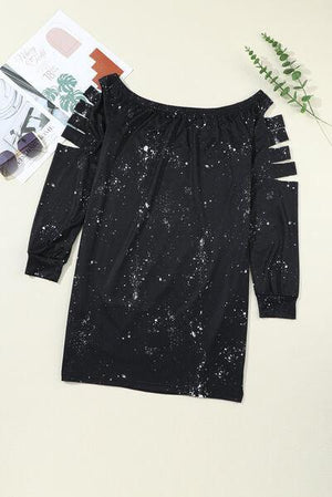 a black off the shoulder dress with white paint splatters