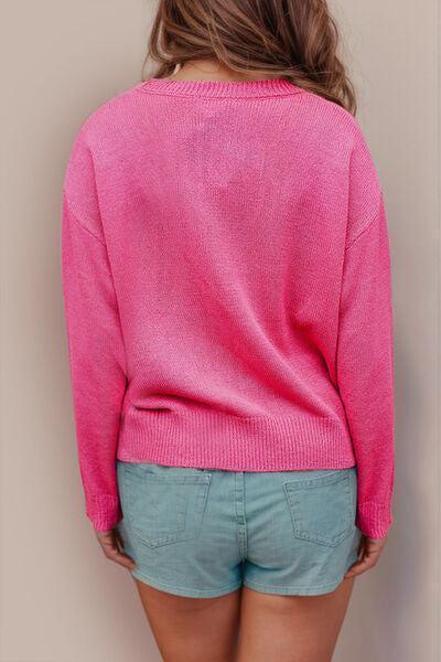 a woman wearing a pink sweater and blue shorts