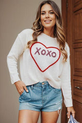 a woman wearing a sweater with the word xoxo on it