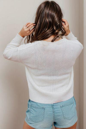 a woman in a white sweater and blue shorts