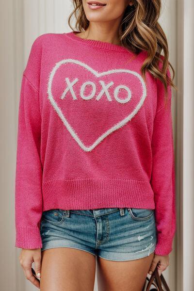 a woman wearing a pink sweater with a heart on it