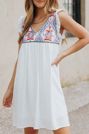 a woman in a white dress posing for a picture