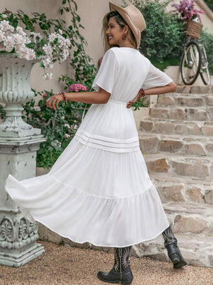 a woman wearing a white dress and hat