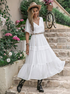 a woman wearing a white dress and a hat