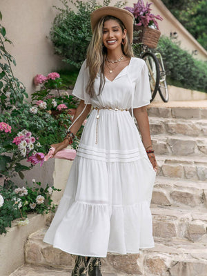 a woman wearing a white dress and hat