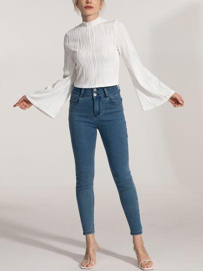 a woman wearing a white top and jeans