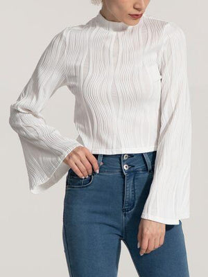 a woman wearing a white blouse and jeans