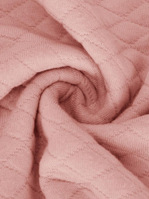 a close up of a pink blanket on a bed