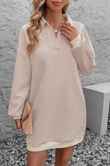 a woman wearing a beige sweater dress