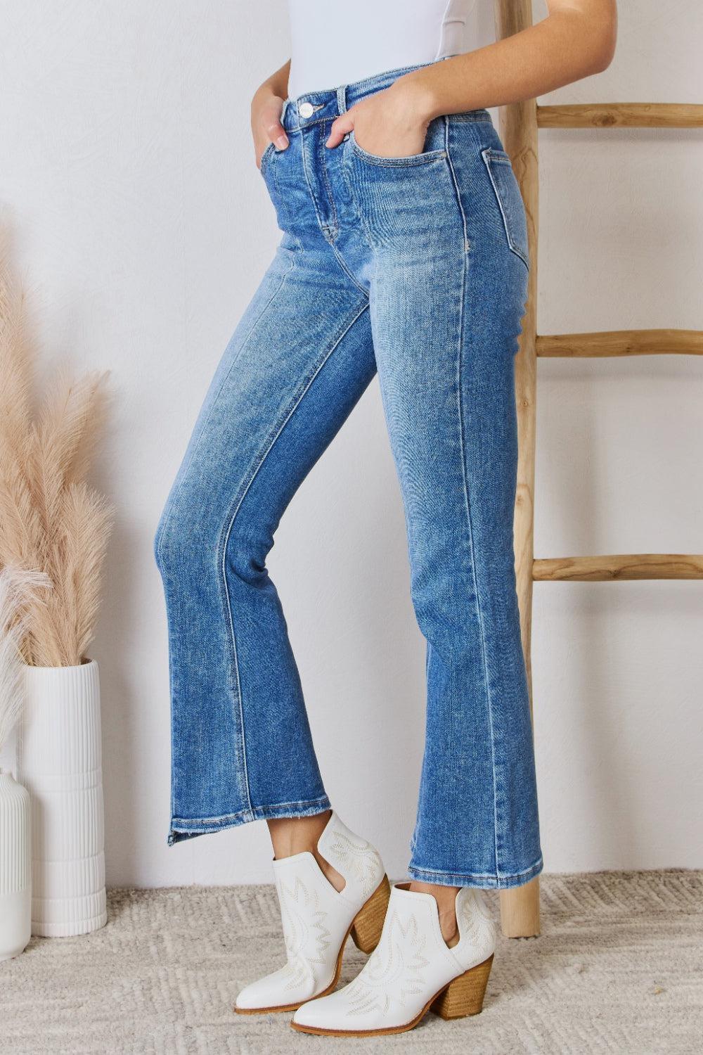 a woman in white shirt and jeans standing next to a ladder