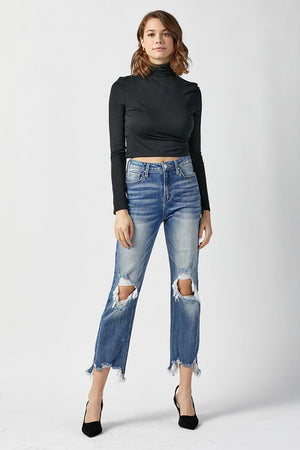 a woman in a black top and ripped jeans