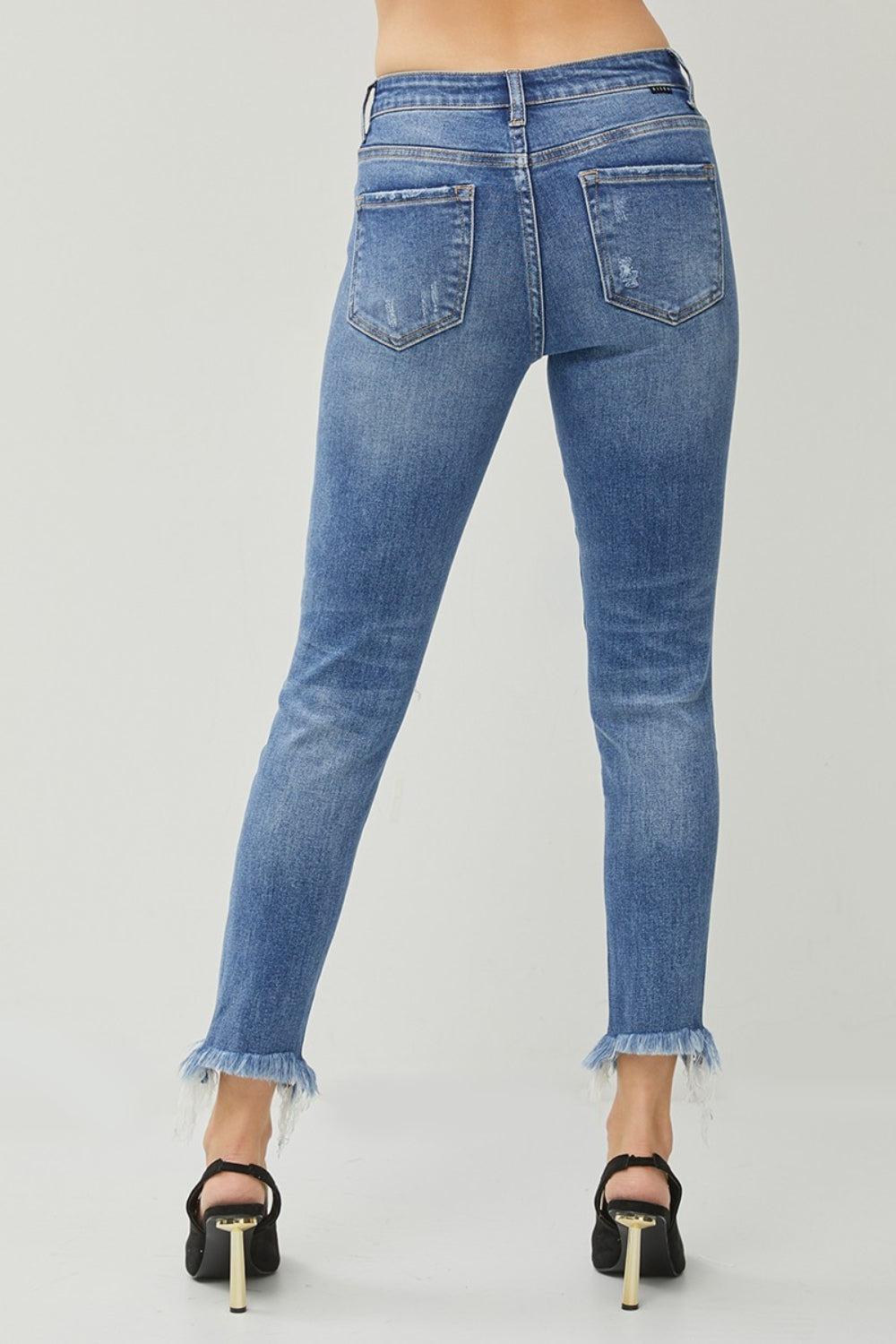 a woman wearing high rise jeans with fraying