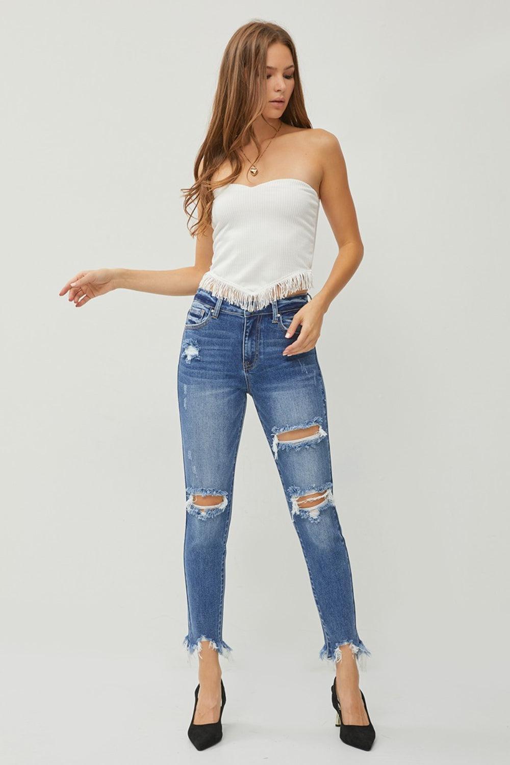 a woman wearing a white top and ripped jeans