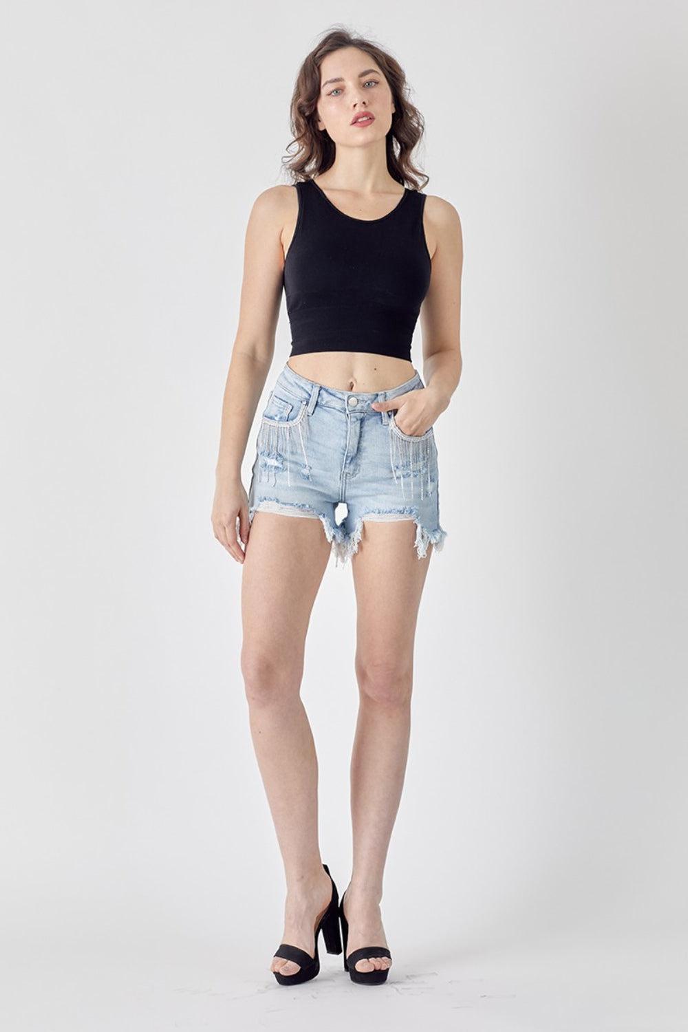 a woman wearing a black tank top and denim shorts
