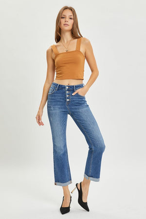 a woman wearing a tan top and jeans