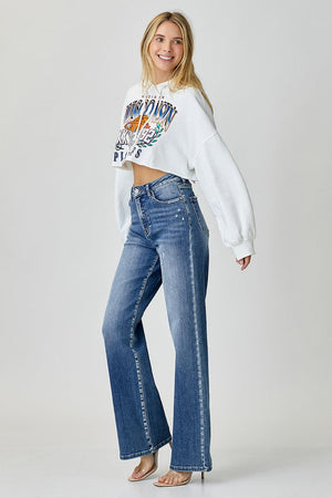 a woman in a white sweatshirt and jeans