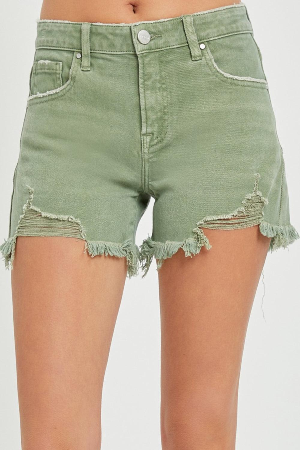 a woman wearing green shorts with holes on the side