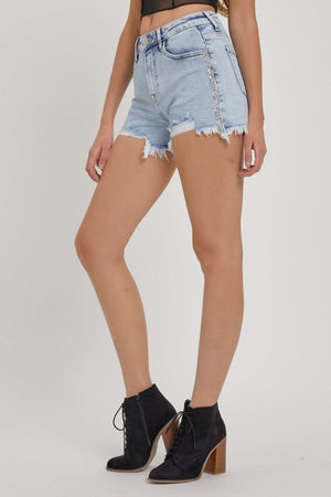 a woman wearing high rise denim shorts and a crop top