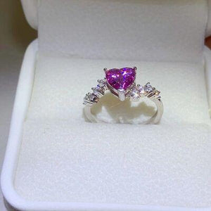 a pink heart shaped diamond ring in a white box