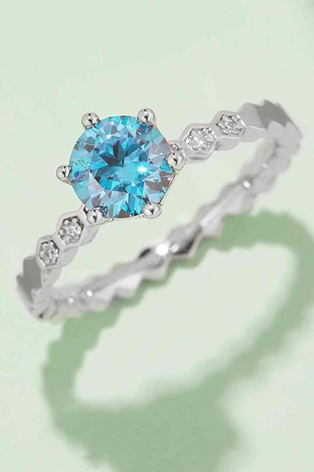 a white gold ring with a blue diamond