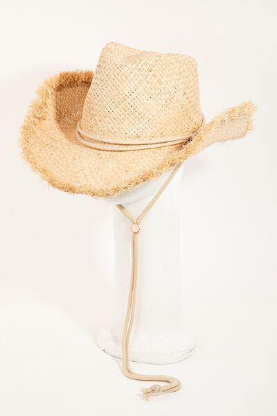 a straw hat sitting on top of a glass vase