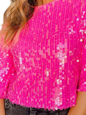 a woman wearing a pink top with sequins