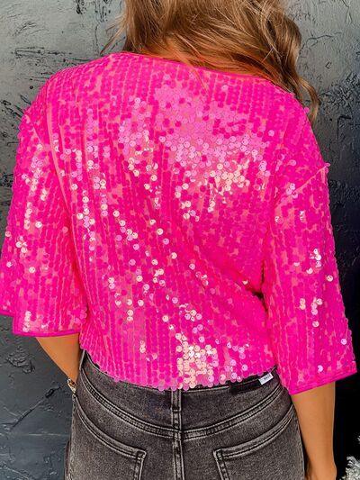 a woman wearing a pink top with sequins