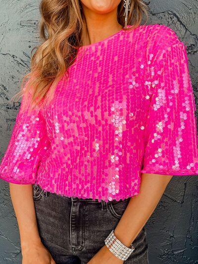 a woman wearing a pink top with sequins