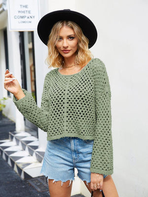 a woman wearing a hat and a green sweater