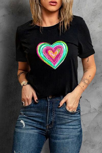 a woman wearing a black shirt with a colorful heart on it