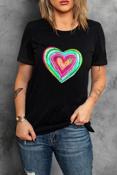 a woman wearing a black t - shirt with a colorful heart on it