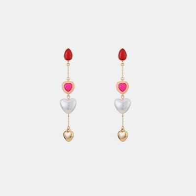 a pair of earrings with hearts hanging from them