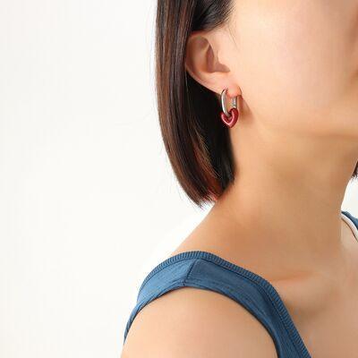 a woman wearing a blue top and a pair of earrings