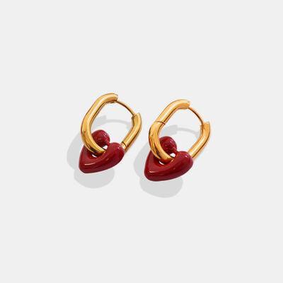 a pair of gold and red earrings on a white background