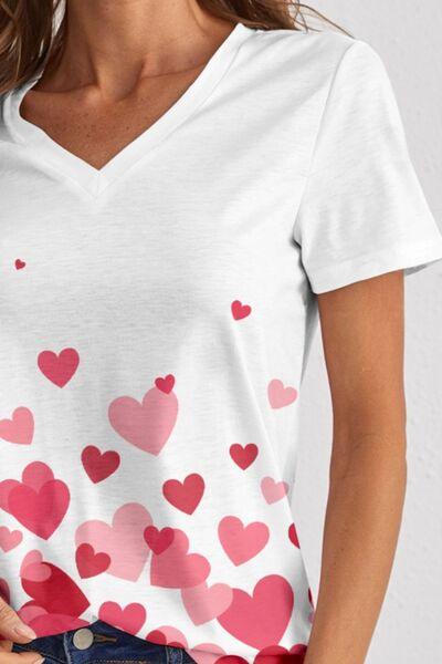 a woman wearing a white shirt with hearts on it