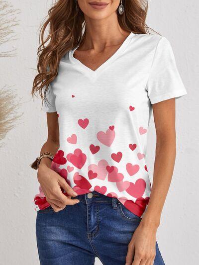 a woman wearing a white shirt with hearts on it