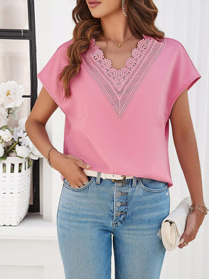 a woman wearing a pink blouse and jeans