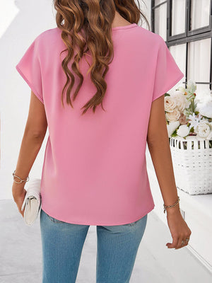 a woman wearing a pink top and jeans