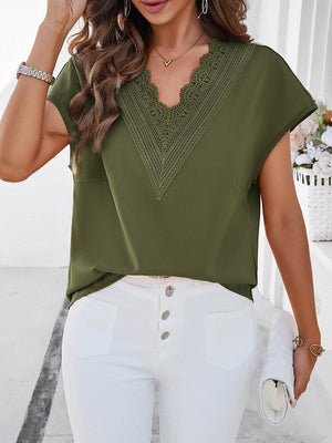 a woman wearing a green top and white pants