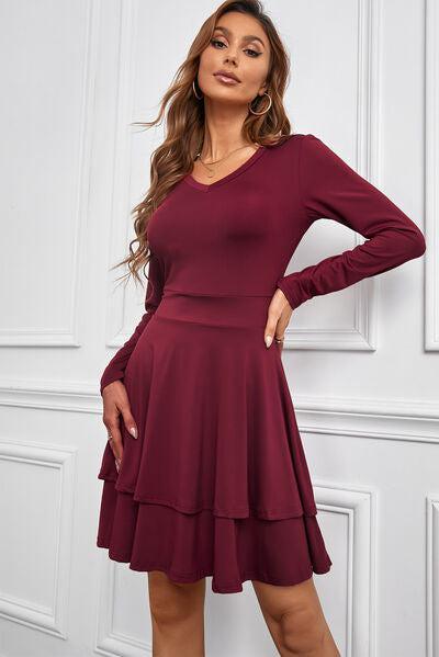 a woman posing in a maroon dress