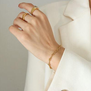 a woman wearing a white coat and a gold ring