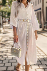 a woman in a white dress is walking down the street