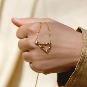 a woman wearing a gold bracelet with a heart on it