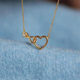 a gold necklace with a heart and a diamond