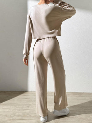 a woman in a white top and beige pants